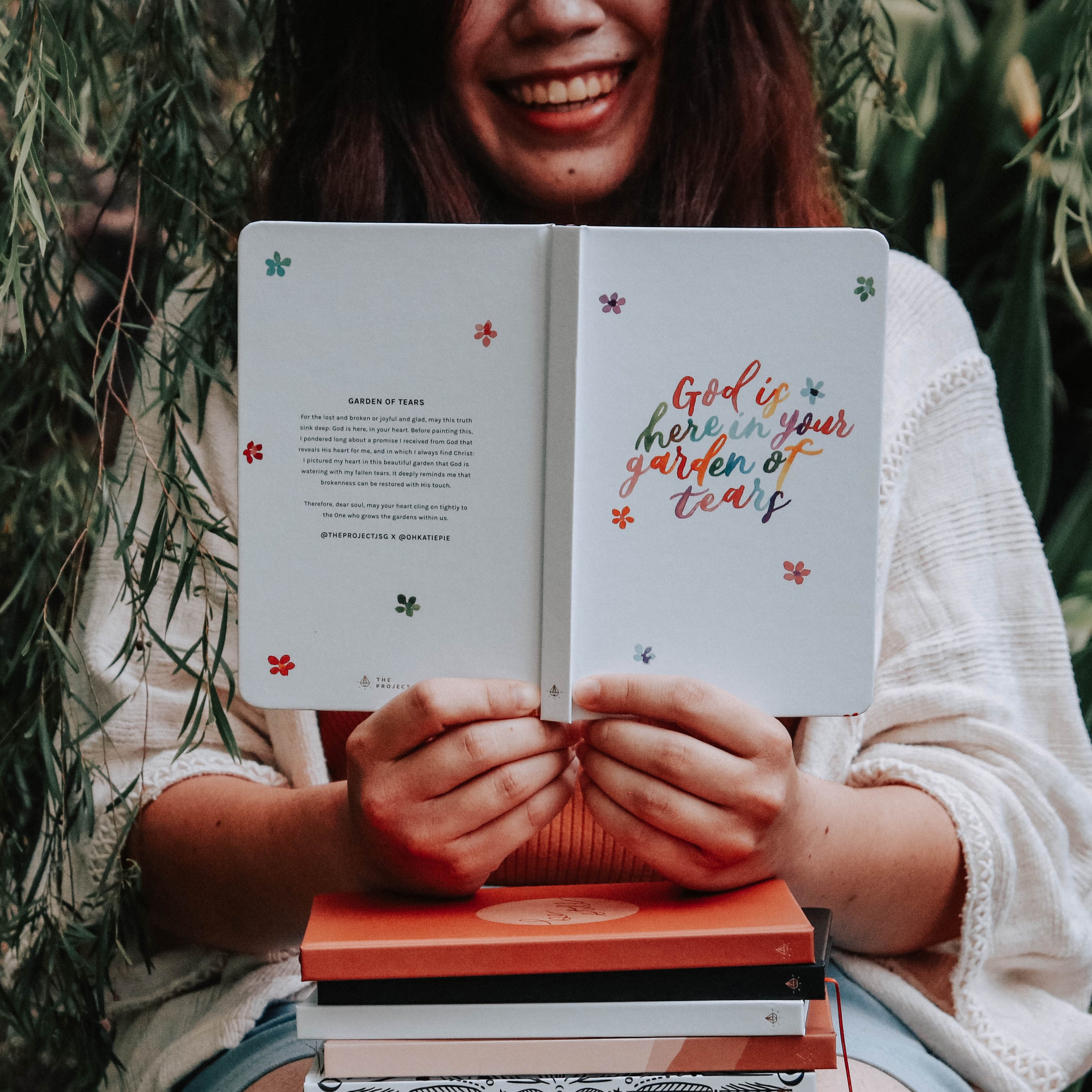 Person holding a book with text outdoors
